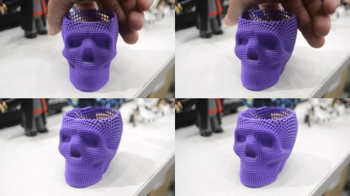 在白色的桌子上，用紫色塑料制成的3D打印人类头骨模型。概念医疗3d打印。增材打印机技术。新型现代创新