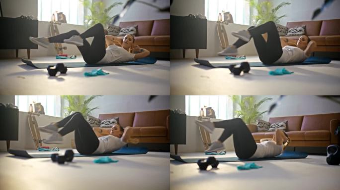 慢动作健身年轻女子在运动垫上做自行车仰卧起坐，在客厅地板上做家庭锻炼。健康的生活方式，积极的生活方式