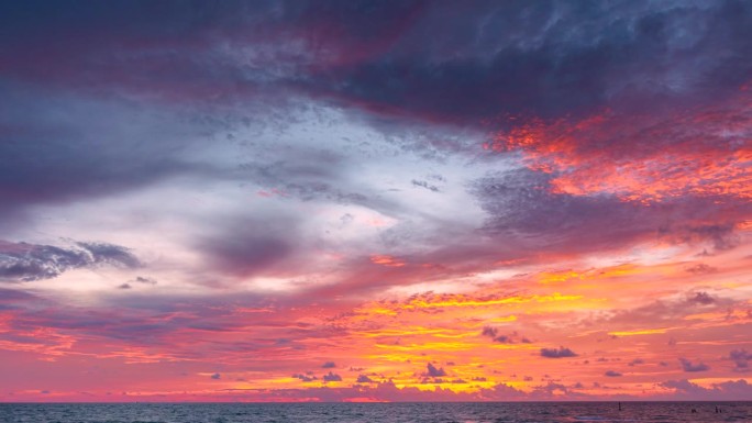 海洋全景。暗橘色的云从白天到夜晚的天空。暴风雨云上壮观的日落。美丽的红色天空。红、紫、橙、蓝、粉红的