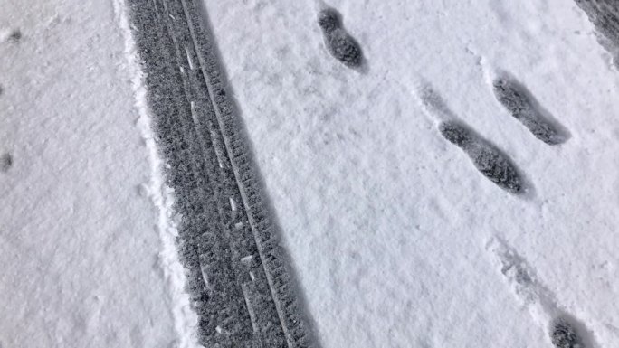 雪地上的汽车轮胎和鞋印