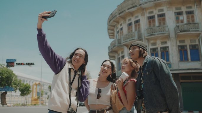 朋友们捕捉快乐的时刻:不同的群体拥抱曼谷的魅力，在探索中分享欢笑和回忆，旅行摄影。