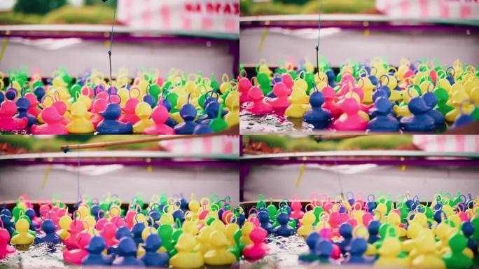 五颜六色的塑料鸭子在游戏池里游泳，孩子试图用鱼竿抓住它们