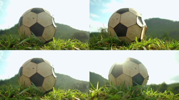 一个破旧的足球躺在草地上。