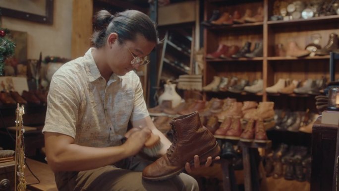 亚洲人在古董店修补旧皮靴