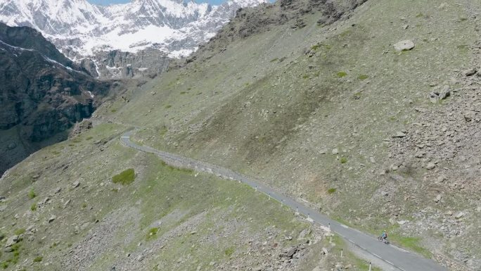 鸟瞰图，一个女人骑着自行车爬上了偏僻的山路