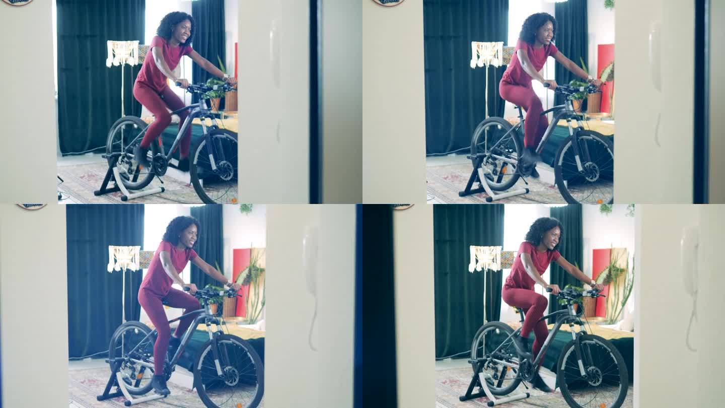 年轻的非洲女士正在家里使用自行车机进行训练