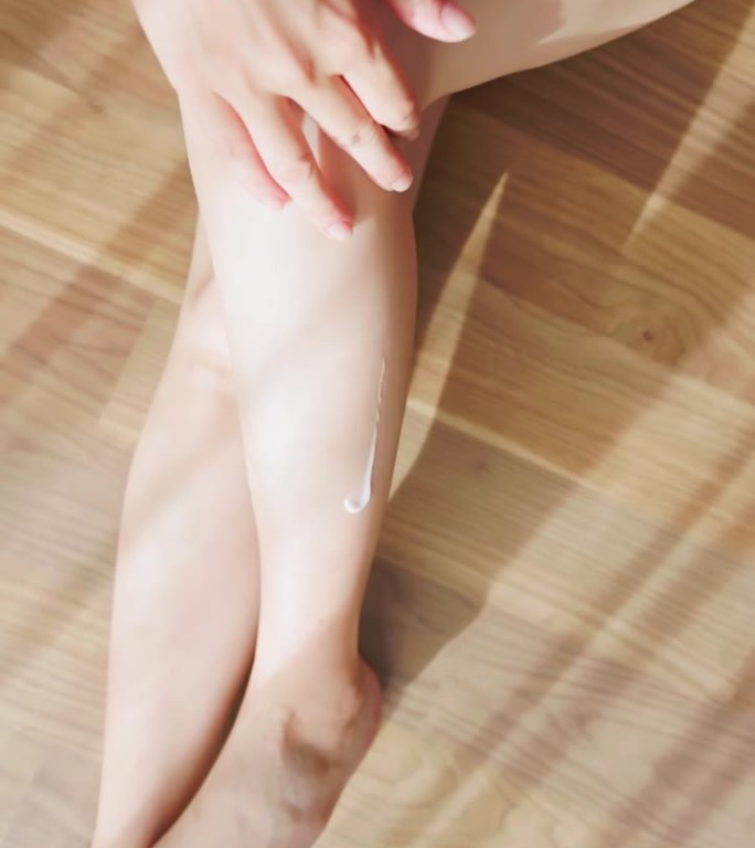 女孩在腿上涂乳液