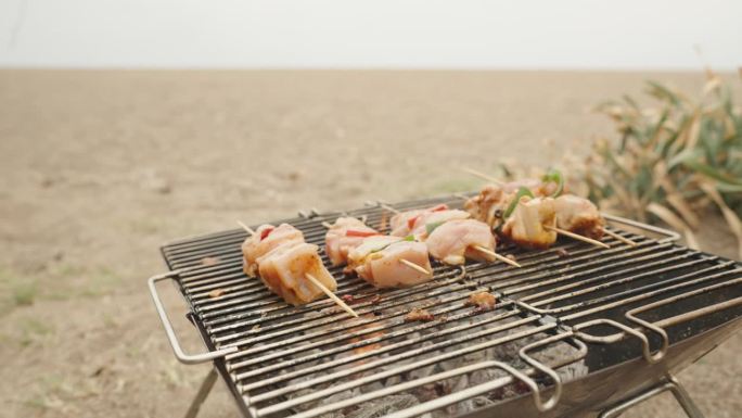 鸡串肉，在海边烤，阴天。