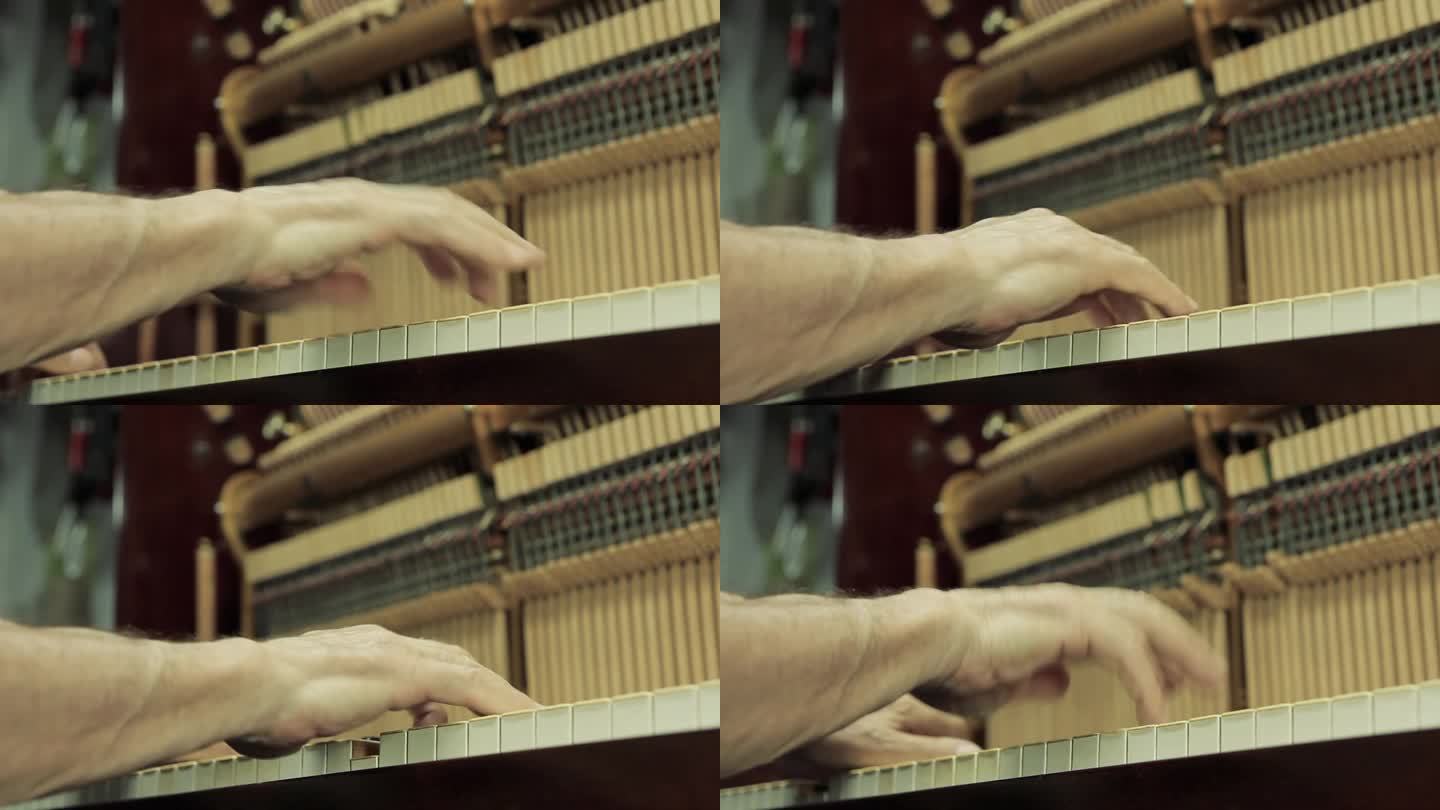 工作中的钢琴调音师，在他的钢琴工作室工作时弹奏钢琴的人的手。关闭了。
