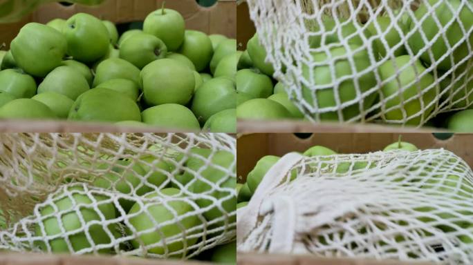 把一个装有青苹果的网眼袋放在盒子里的苹果上面。