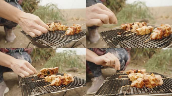 女人用木棍炸鸡肉，在海滩上野餐。便携式烧烤。