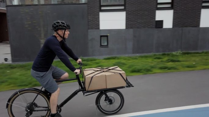 骑自行车的邮递员用他的货运自行车送包裹