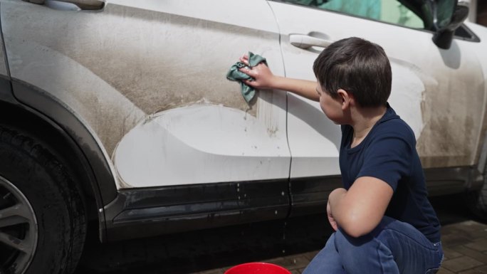 小男孩在洗脏车