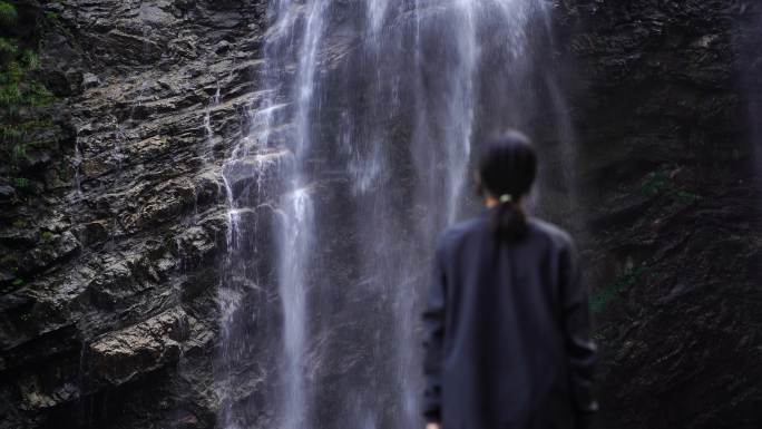 女性人物背影感受亲近自然登顶山峰瀑布水流