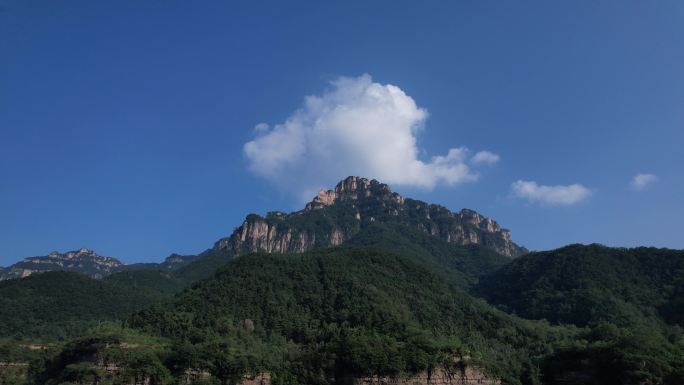 苍翠大山山顶的一朵白云航拍