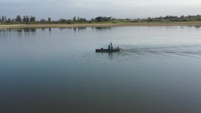 航拍两农民乘船在鱼塘抛撒饲料