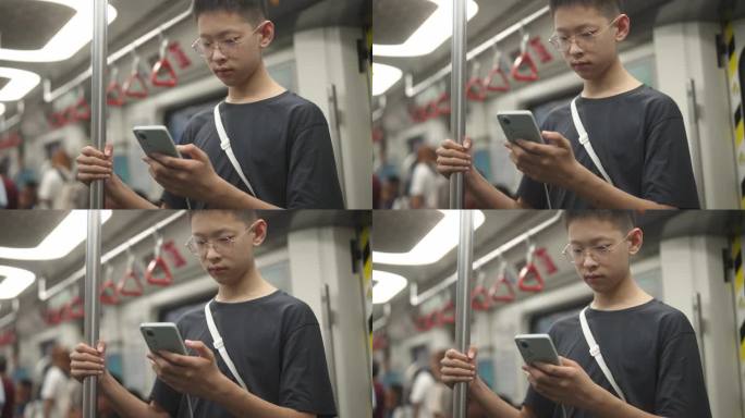 男生在地铁站看手机