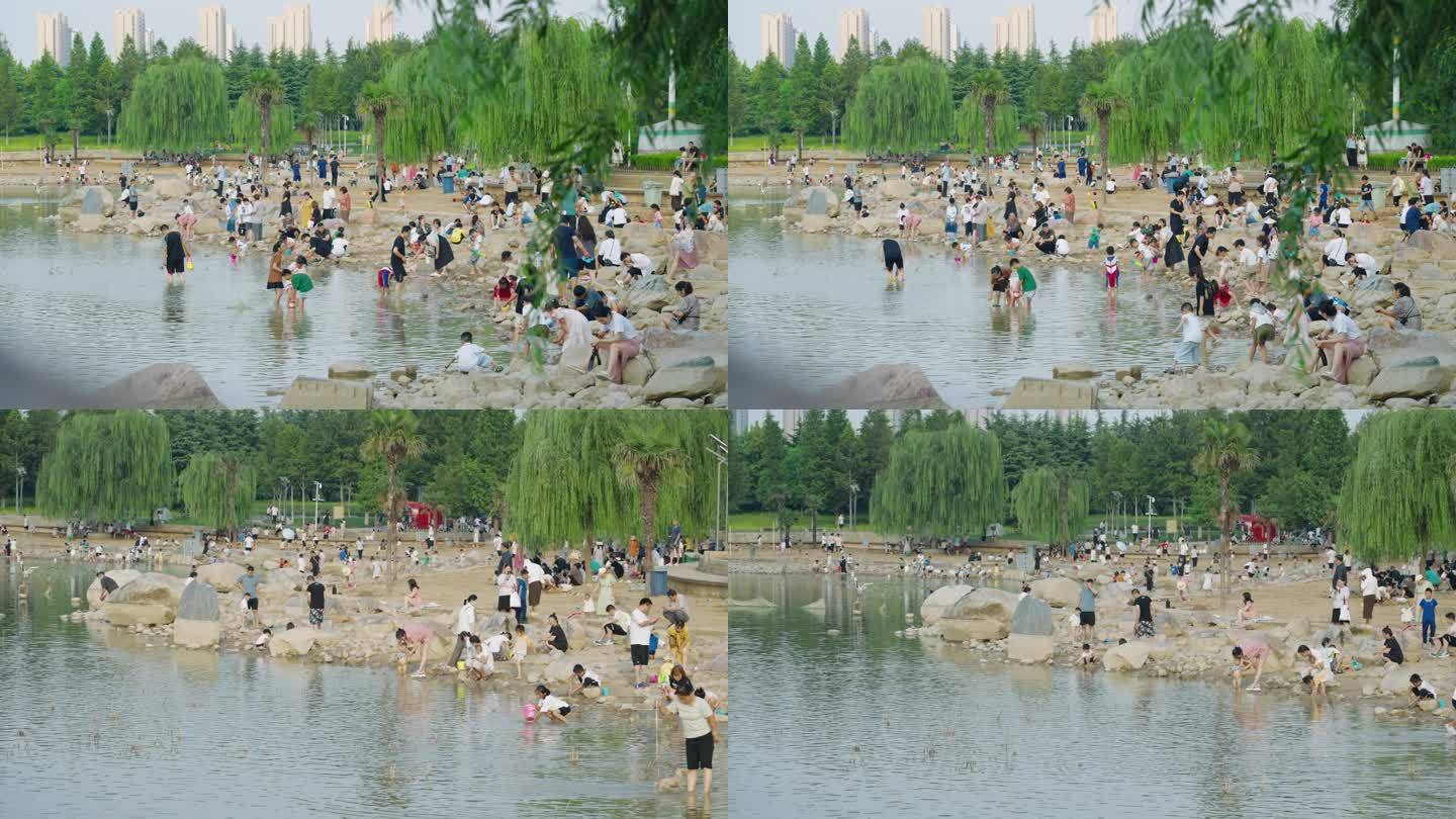 大面积沙滩人群小孩玩沙子城市绿化水系