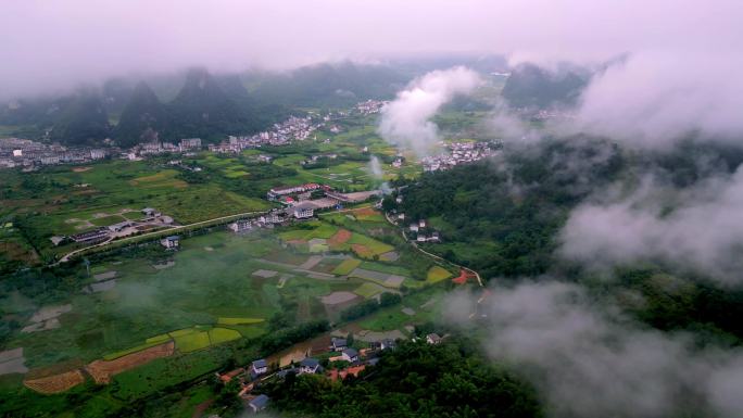 桂林喀斯特地貌山间村庄和稻田上漂浮着薄雾