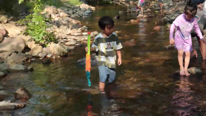 儿童在小溪中玩水抓鱼