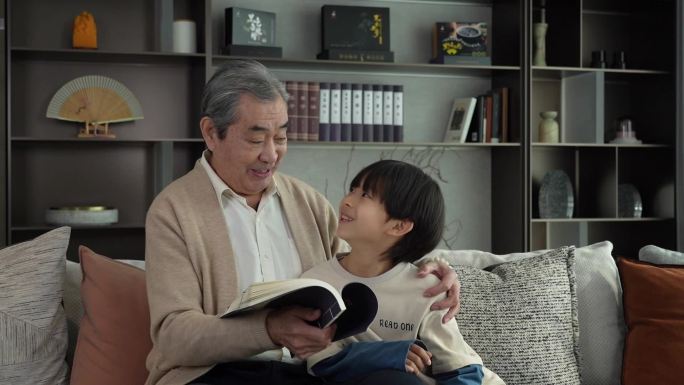 老人和孩子一起在客厅读书