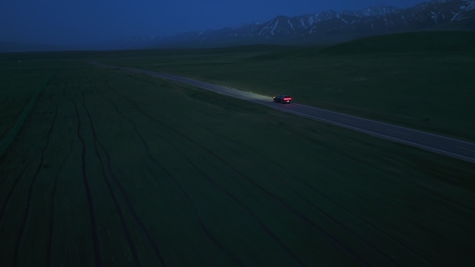 新疆那拉提草原上行驶的新能源汽车