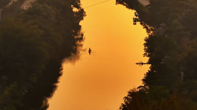 桂林山水漓江朝阳中划船清理湖面的人跟渔船