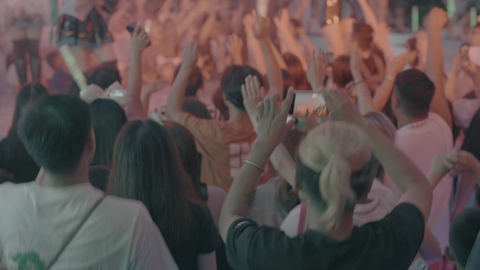 演唱会歌迷举起双手和手机