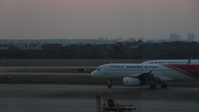 夕阳背景下机场飞机起降场景