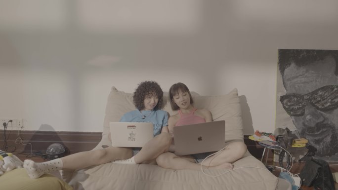 女生和朋友在床上玩电脑