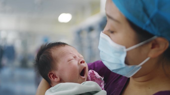 医院医生护士新生儿婴儿怀抱中哭啼温暖感人