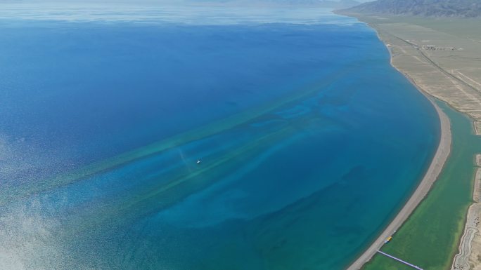 新疆赛里木湖波光粼粼湛蓝湖水中的游船小船