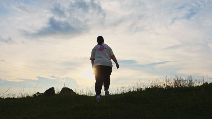 一个肥胖的女人在山顶奔跑运动减肥