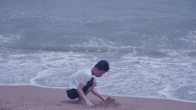 海边堆沙小男孩