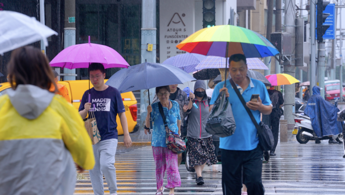 城市下雨街道雨天打伞过马路行车水花溅起