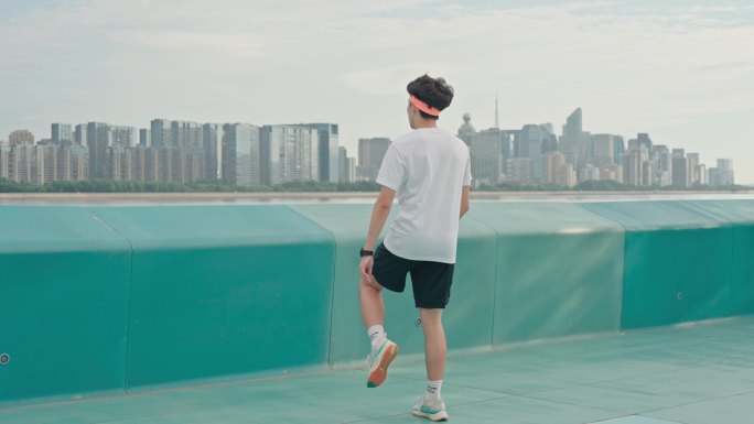 年轻人跑步热身 城市江边公园跑步