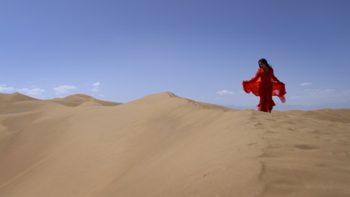 一个身穿红色长裙的女人在沙漠中奔跑红裙