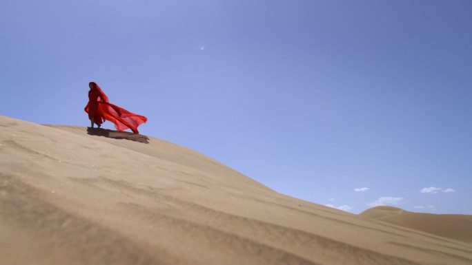 一个身穿红色长裙的女人在沙漠中奔跑红裙
