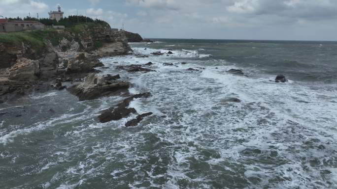 航拍威海国际海水浴场波涛汹涌的礁石海浪