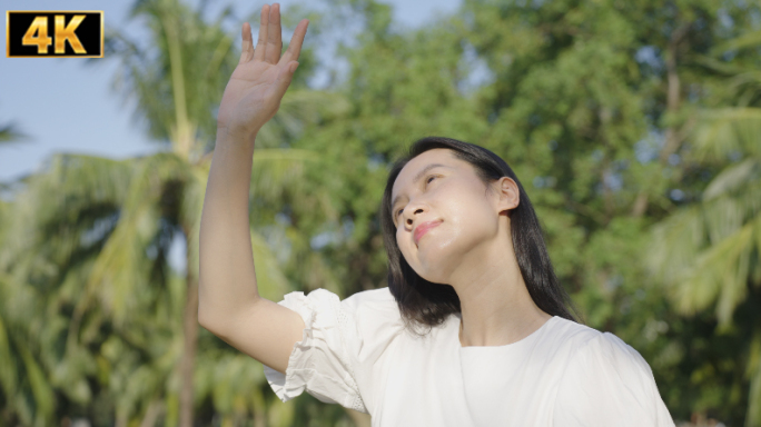 女孩在树林行走伸手遮挡阳光亲近自然