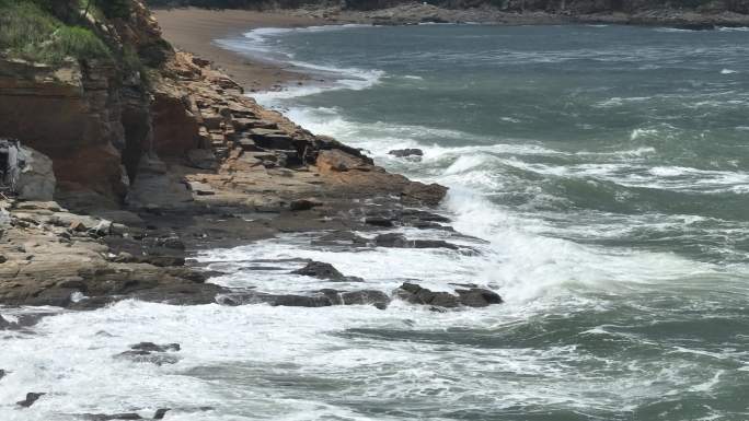 航拍威海国际海水浴场波涛汹涌的礁石海浪