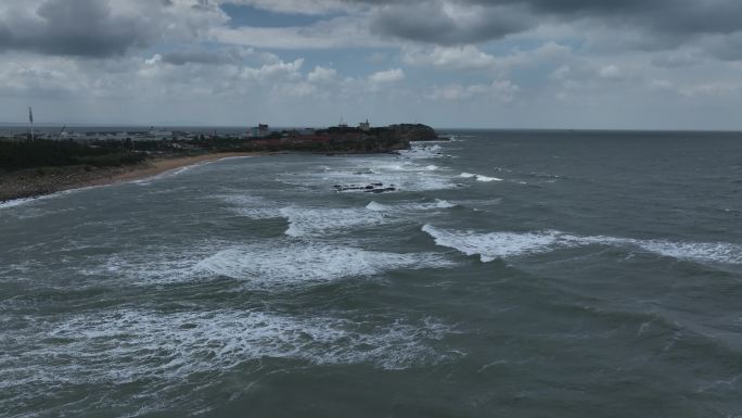 航拍威海国际海水浴场波涛汹涌的礁石海浪