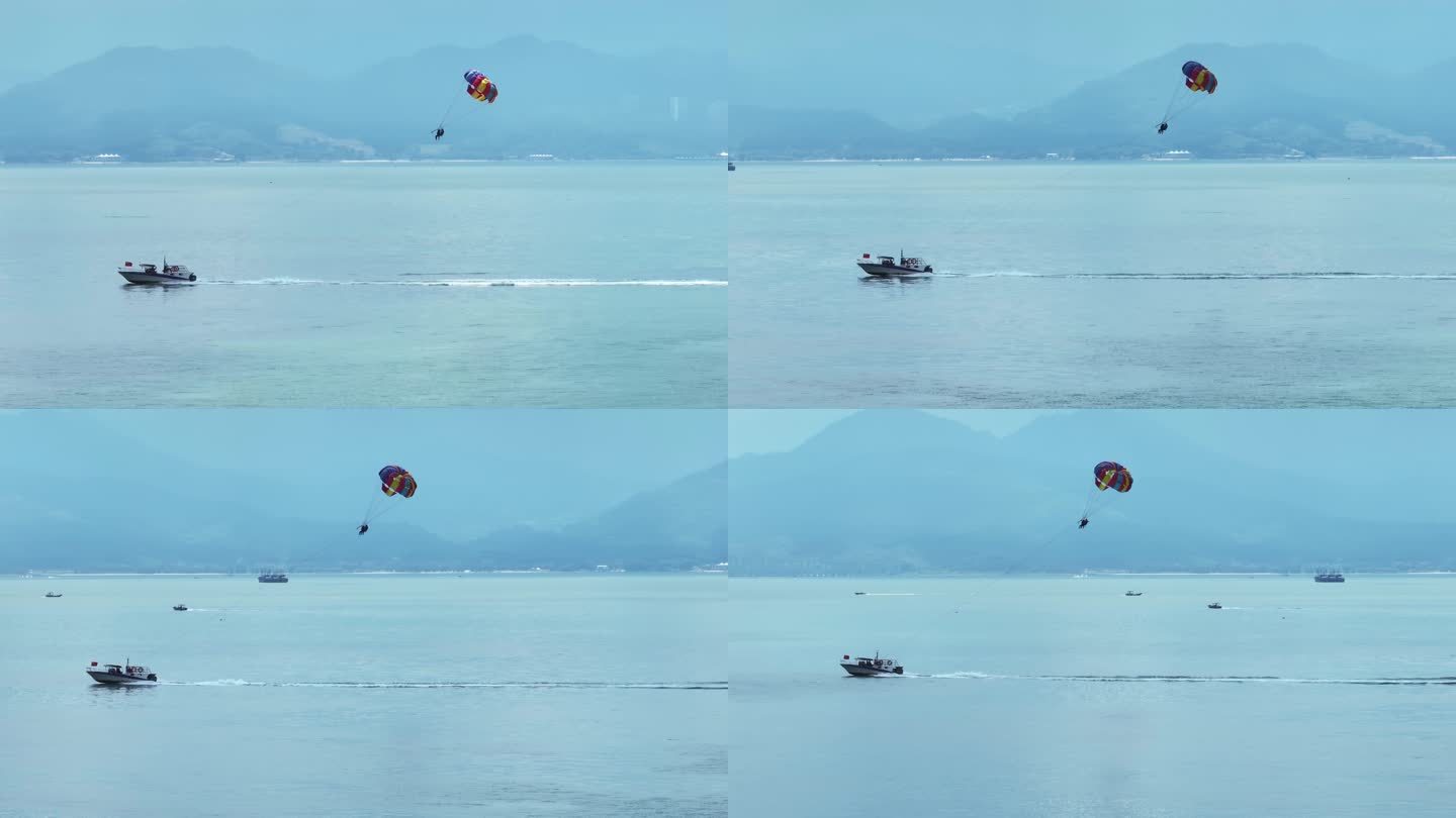 航拍海上快艇拖拽滑翔伞飞翔的极限运动