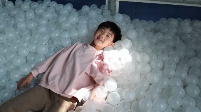 男孩在室内游乐场玩塑料球4k升格慢镜
