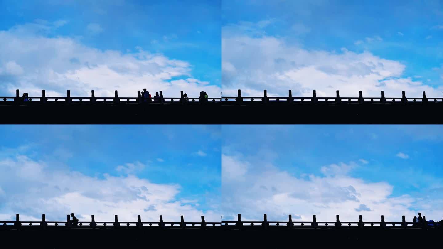 行人在桥上匆匆走过的剪影天空云层流逝背景