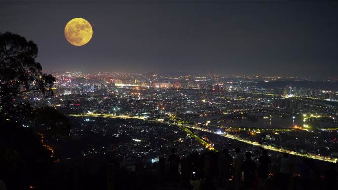 山顶上中秋赏月城市上空月亮升起十五的月亮
