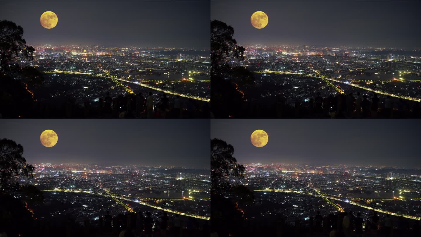 山顶上中秋赏月城市上空月亮升起十五的月亮