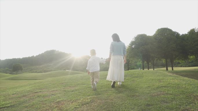 打手牵小手妈妈陪伴孩子公园散步温馨家庭