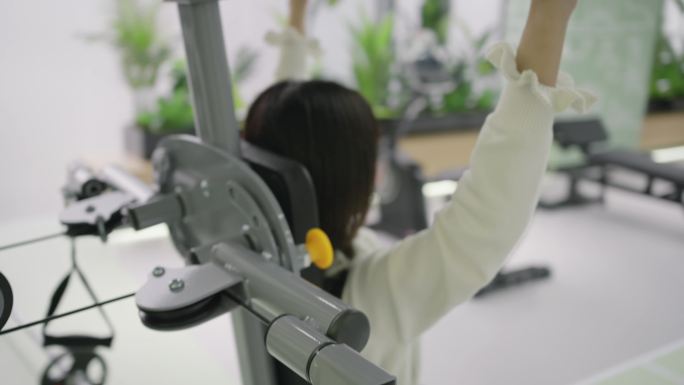 女生在健身房使用建设器械锻炼身体