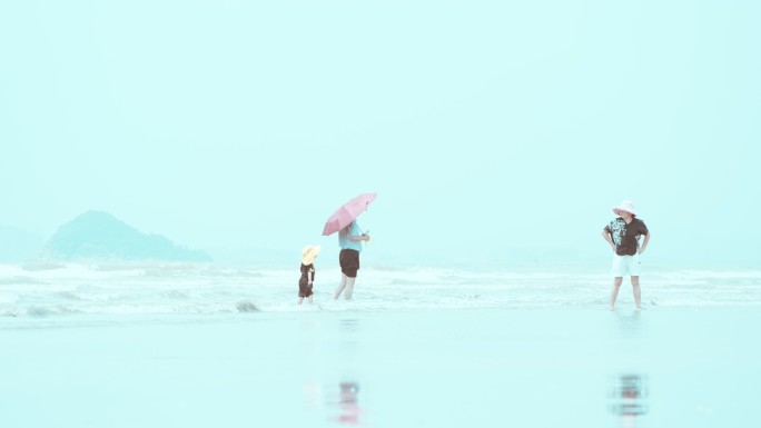 一家三口在海边游玩愉快的拍照-04